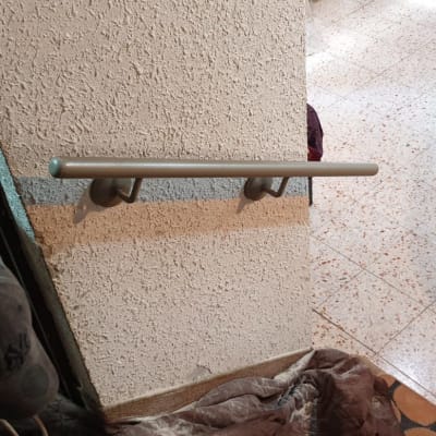 אדם מתקין מעקה מתכת על קיר