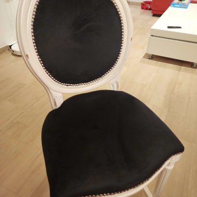 כיסא מרופד בבד שחור עם מסגרת לבנה