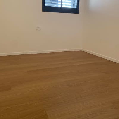 רצפת פרקט עץ בחדר עם קיר לבן