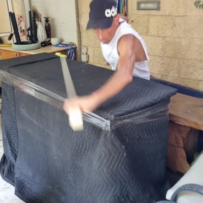 אדם עוטף רהיט בשמיכה שחורה להגנה