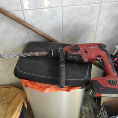 מקדחה אדומה עם מקדח גדול על פח אשפה