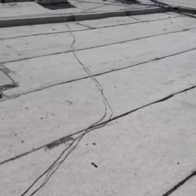 גג עם יריעות איטום ואדם עומד ליד מזגן