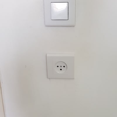 שקע חשמל ומתג על קיר לבן