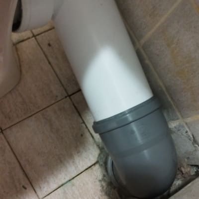 צינור פלסטיק לבן ואפור מחובר לרצפה