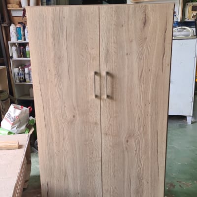 ארון עץ עם ידיות מתכת בסדנת נגרות