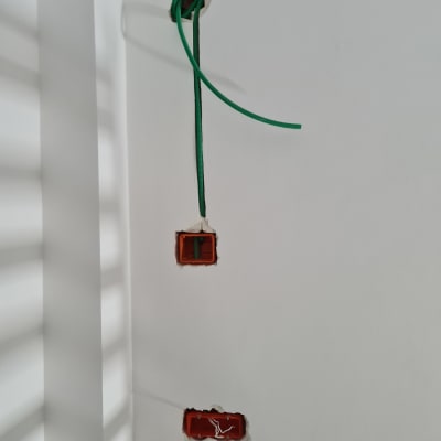 חוטי חשמל ירוקים יוצאים מקיר לבן