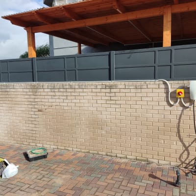 עמדת טעינה לרכב חשמלי על קיר לבנים עם כבלים וכלי עבודה