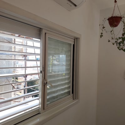 קיר צבוע בלבן ליד חלון עם תריסים