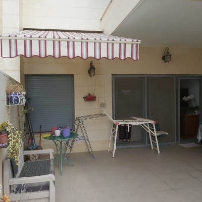 סוכך פסים אדומים ולבנים תלוי מעל מרפסת