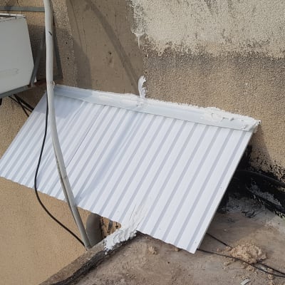 גג אלומיניום לבן מותקן על קיר חיצוני