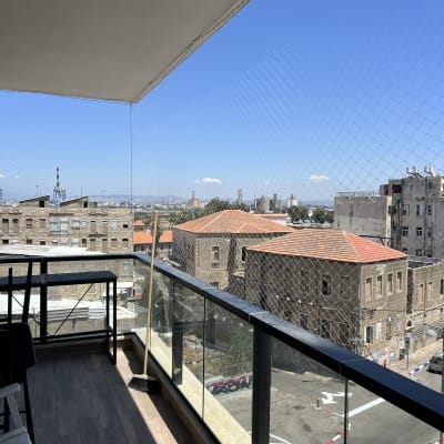 רשת נגד יונים מותקנת על מרפסת עם נוף עירוני