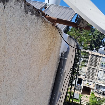 צלחת לוויין על גג עם כבלים חשמליים