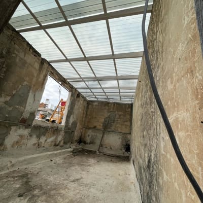 חדר עם קירות בטון ותקרה שקופה למחצה