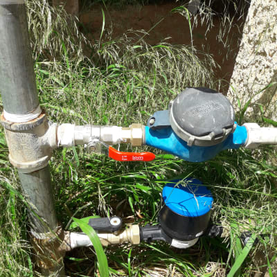 צינורות מים עם ברזים ומדי מים בגינה