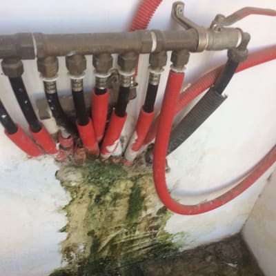 צינורות מים עם חיבורים ודליפה על הקיר