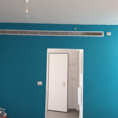 קיר צבוע בכחול עם דלת לבנה פתוחה