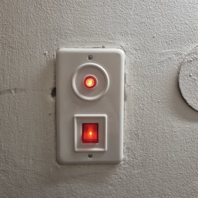 שני מתגים עם נורות אדומות דולקות על קיר