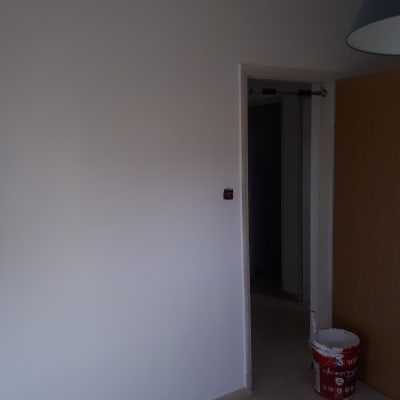 קיר צבוע לבן ודלי צבע אדום