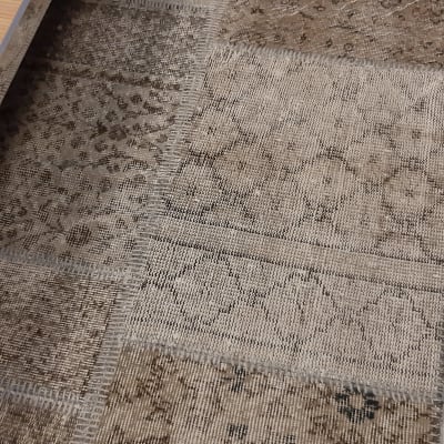 שטיח עם דוגמאות גיאומטריות בצבעים חומים