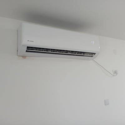 מזגן קיר לבן מותקן על קיר לבן