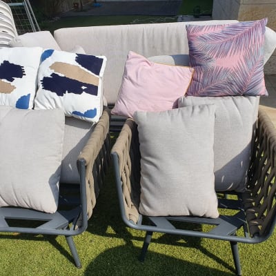 כריות על ספות חיצוניות בגינה עם דשא סינתטי