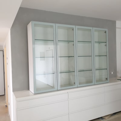 ארון זכוכית עם מדפים על קיר צבוע אפור