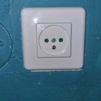 שקע חשמל לבן על קיר כחול