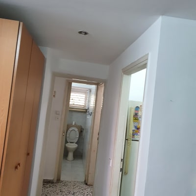 מסדרון עם קירות צבועים בלבן ודלתות