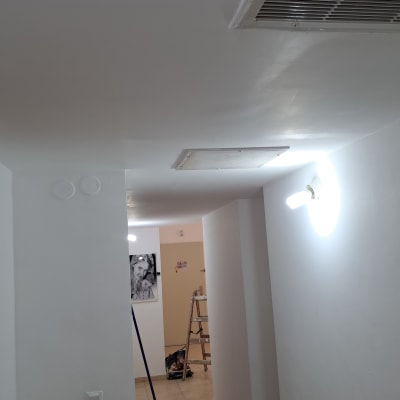 דלי צבע ומברשת במסדרון עם קיר גבס