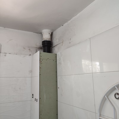 צינור שחור מחובר לתקרה בחדר אמבטיה