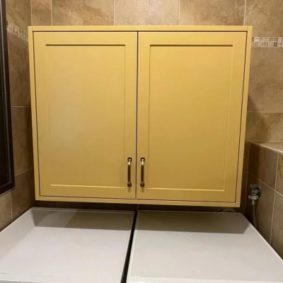 ארון עץ צהוב עם שתי דלתות וידיות מתכת