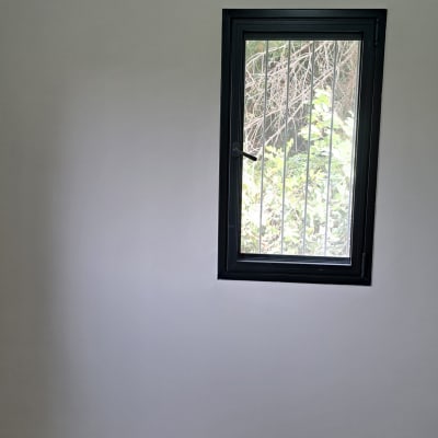 קיר צבוע בלבן עם חלון קטן ומזגן