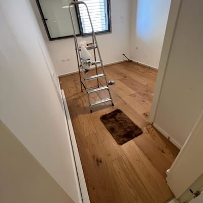 רצפת פרקט עץ בחדר עם סולם מתכת