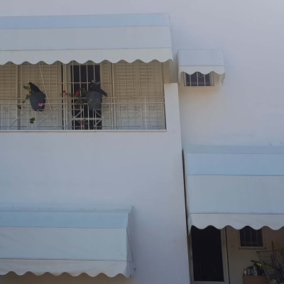 סוככים לבנים מעל חלונות ומרפסת