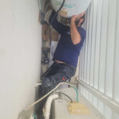 אדם עובד על דוד שמש עם צינורות וחיבורים