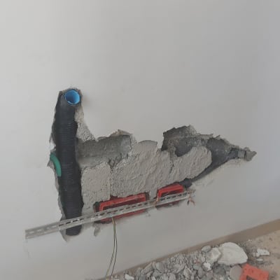 קיר עם חוטי חשמל וצינורות חשמל חשופים