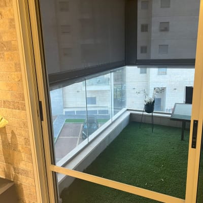 מרפסת עם דשא סינתטי, חלון זכוכית ומסגרת אלומיניום