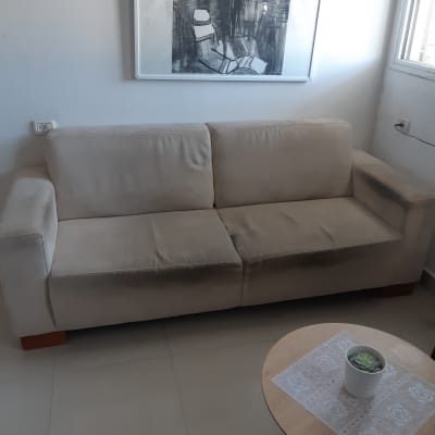 ספה בהירה עם כתמים כהים על המושב והמשענת