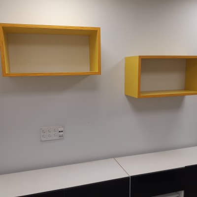 שתי מדפים צהובים מותקנים על קיר לבן