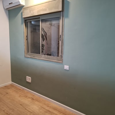 רצפת פרקט עץ בחדר עם קיר צבוע ירוק