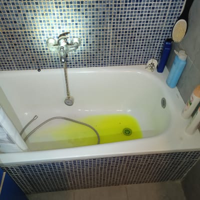 אמבטיה עם מים צהובים וצינור מתכת