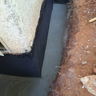 קיר אטום בזפת עם בטון טרי בתעלה