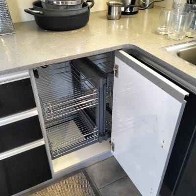 ארון מטבח פתוח עם מדפים נשלפים וסירים על השיש