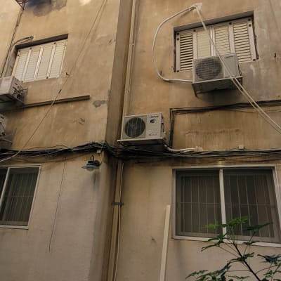 בניין עם מזגנים מותקנים על הקיר החיצוני