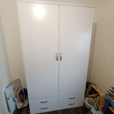 ארון לבן עם ידיות מתכת ומגירות תחתונות