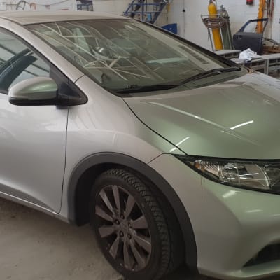 מכונית כסופה בחלל עבודה עם כלי עבודה ברקע