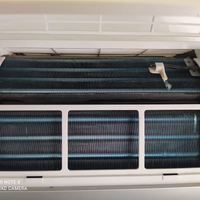 סלילי מתכת במזגן עם כיסוי פלסטיק לבן