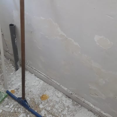 קיר מתקלף עם שאריות צבע על הרצפה