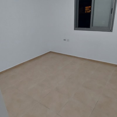 חדר ריק עם קירות לבנים ורצפת אריחים