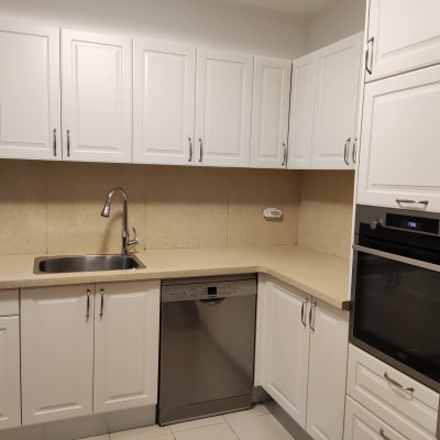 מטבח עם ארונות לבנים, כיור וברז נירוסטה